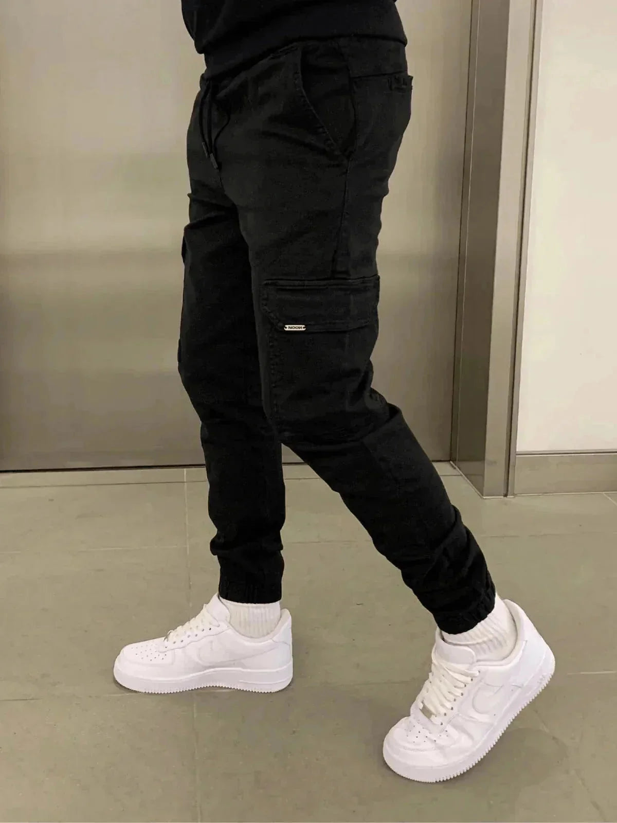 Black Men's Slim-Fit Cargo Joggers with Drawstring Waist & Elastic Cuffs — Leo - Side Walking Pose