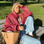 Wine Red Women's Oversized Quilted Bomber Jacket with Contrast Stitching & Zip Front - Outdoor Seated Lifestyle